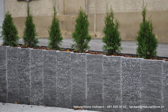 Granitstelen als Sttzmauer fr ein Gartenbet aus Tessiner Gneis.